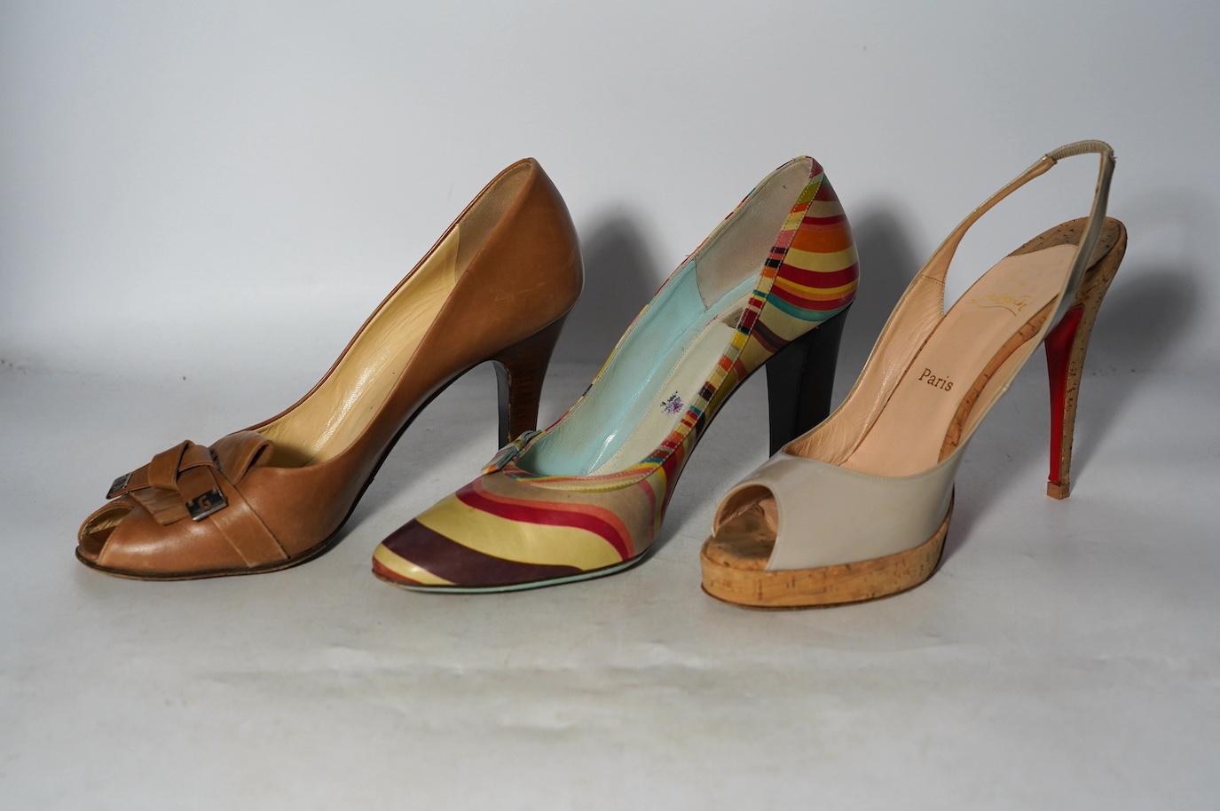 A pair of Christian Louboutin nude patent leather open toe heeled pumps, a pair of Dolce & Gabbana light tan open toe pumps and a pair of Paul Smith signature stripe heeled pumps, all size 41